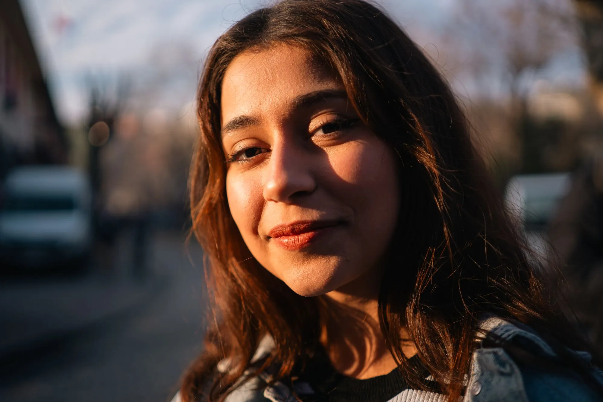 A young woman smiling in warm golden-hour light