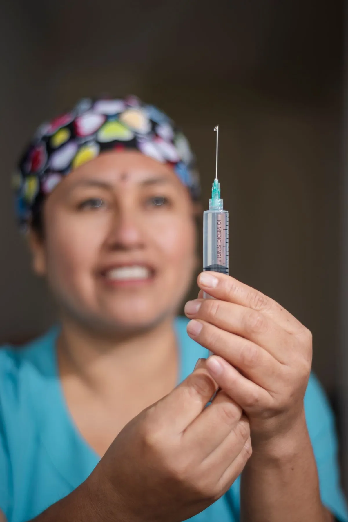 A smiling nurse preparing a flu shot