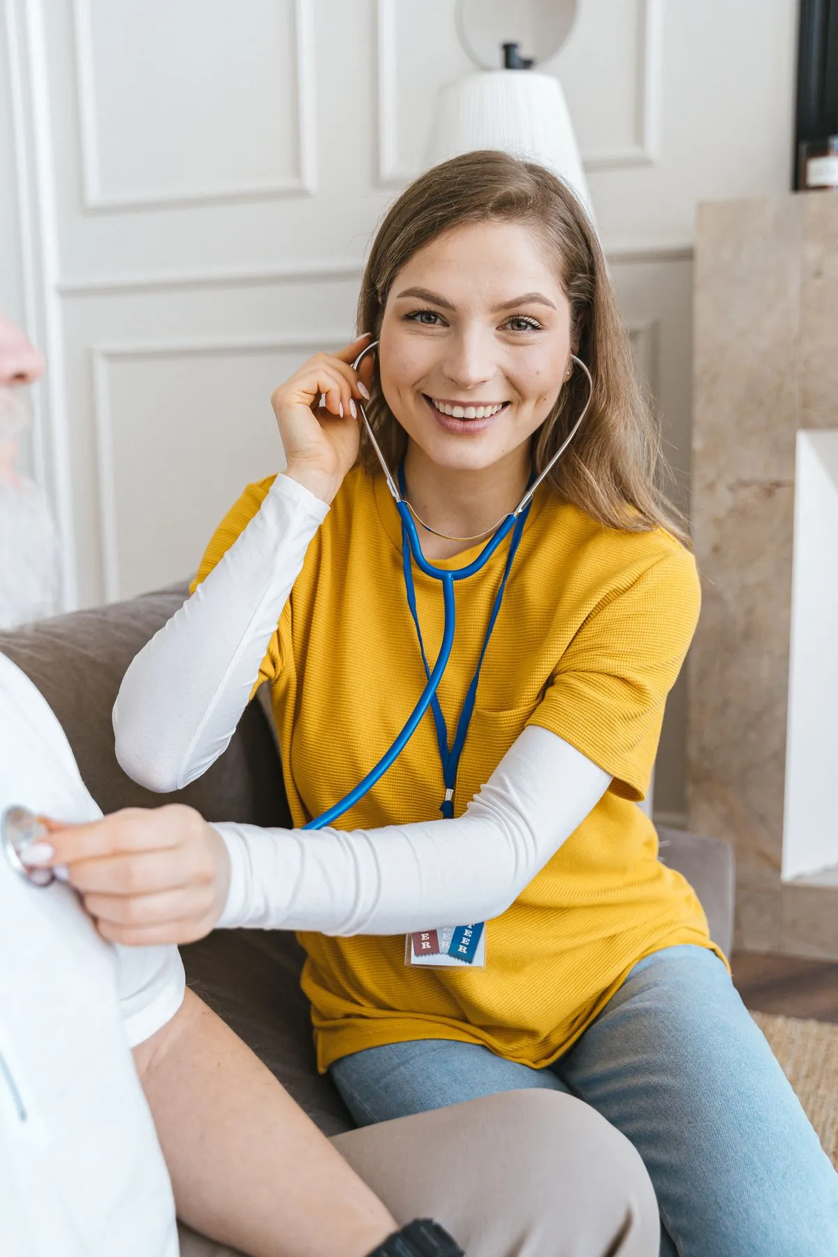 A community health worker checking in with an older patient at home